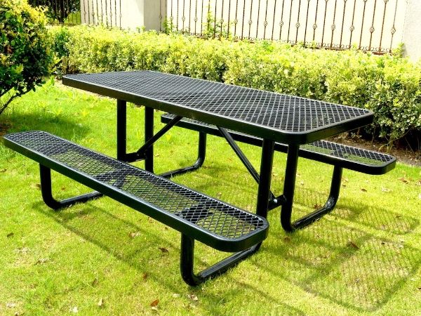 A set of black expanded metal desk and chair is placed on the lawn.