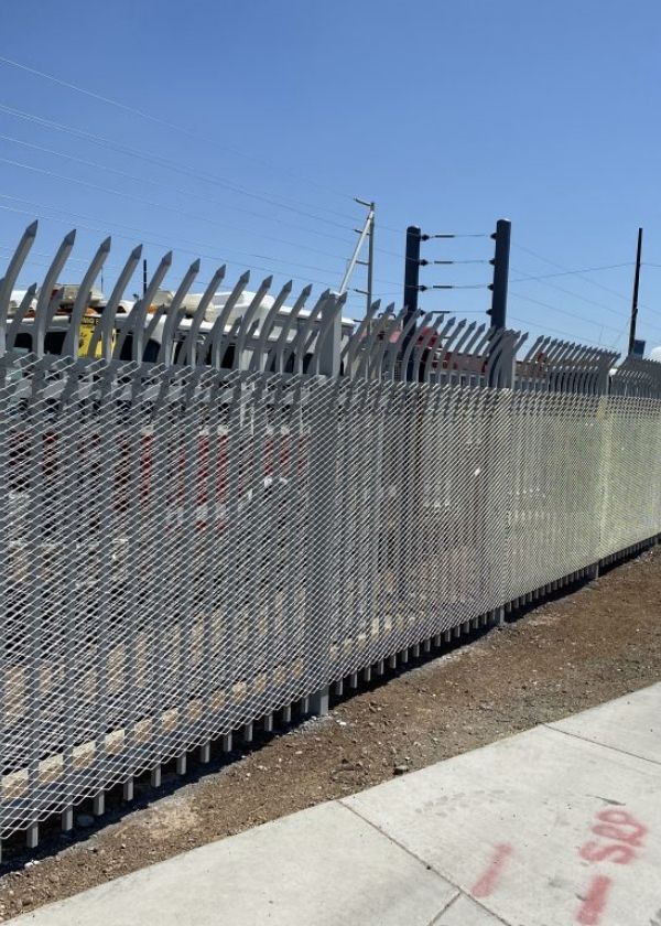 Expanded metal security fence is installed with metal frames.