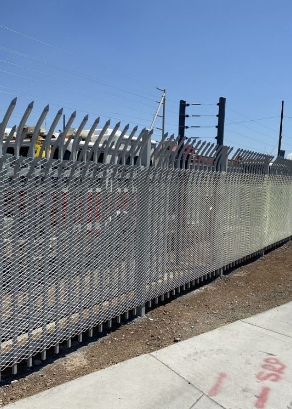 Expanded metal security fence is installed with metal frames.