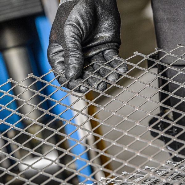 The worker is testing the flatness of the expanded metal.