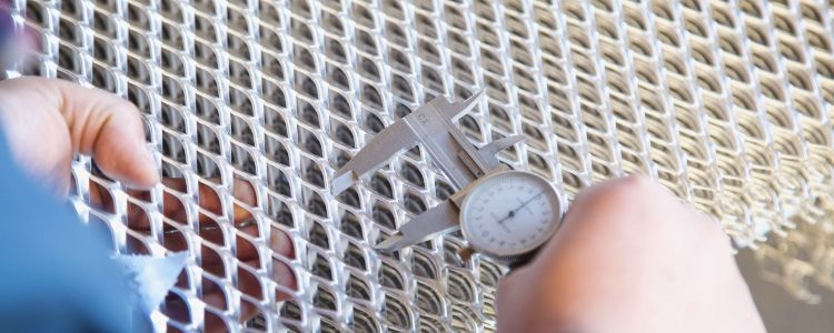 Our worker is measuring the LWD of the expanded metal with a caliper.