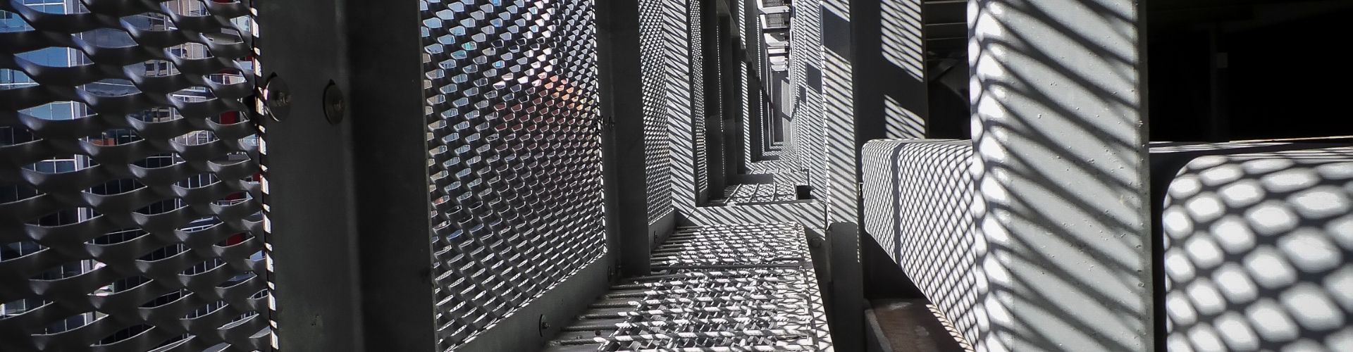 Sunlight passes through the expanded metal sunshade and leaves a shadow.