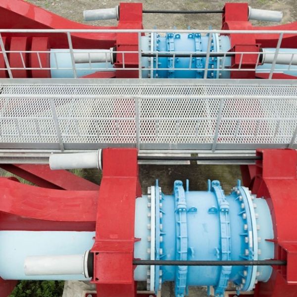 Expanded metal walkway is built above overhead pipes.