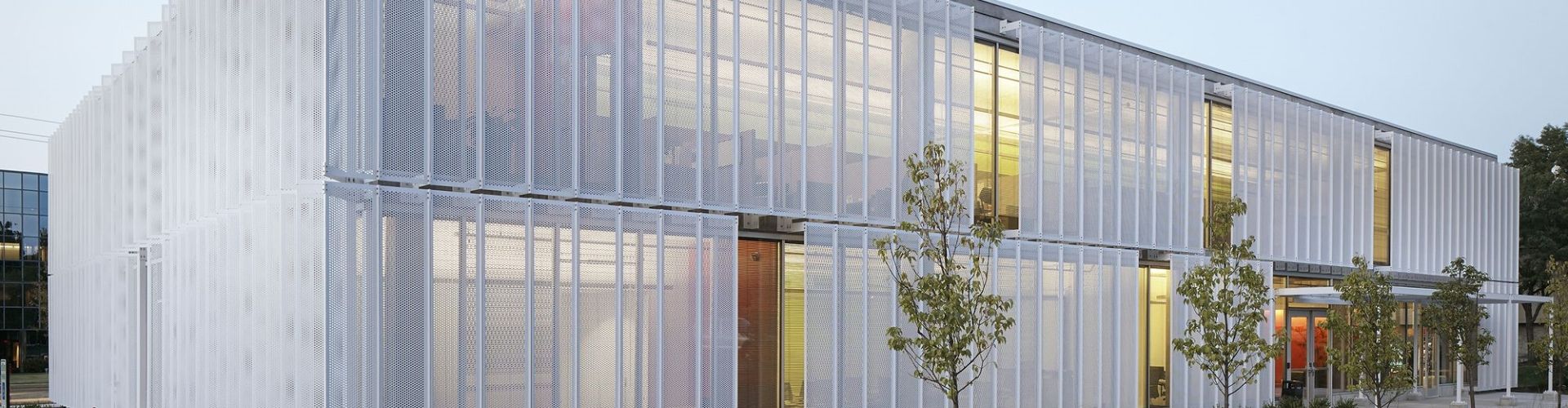 White expanded metal facade is installed on the exterior walls of the building.